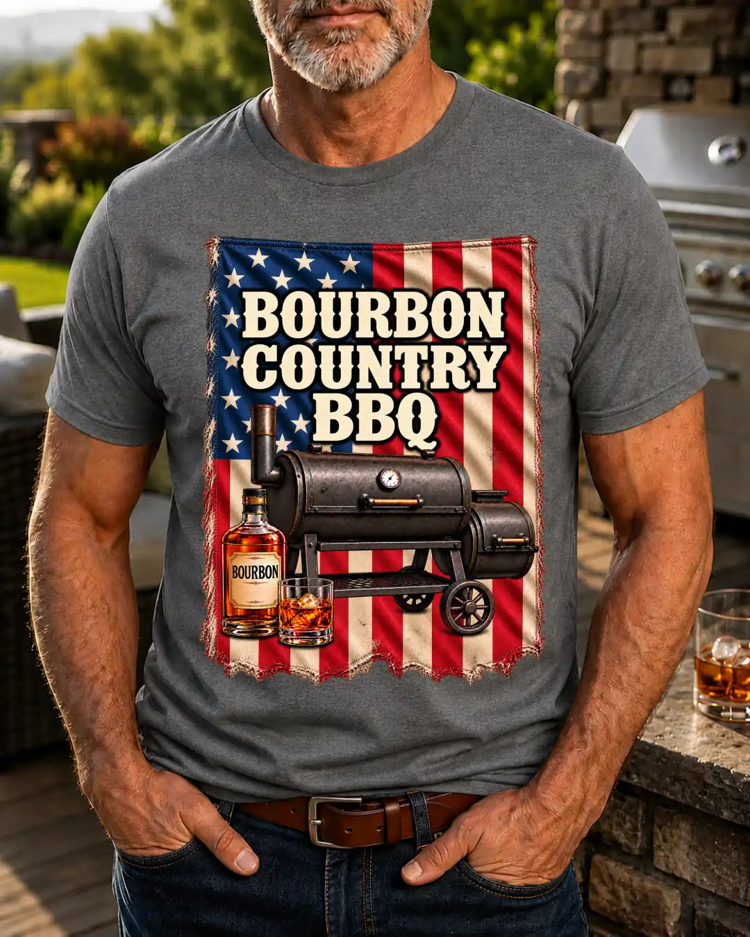 A man wearing a gray t-shirt with a 'Bourbon Country BBQ' graphic featuring an American flag, a smoker's grill, and a bottle of bourbon, set against an outdoor patio background.