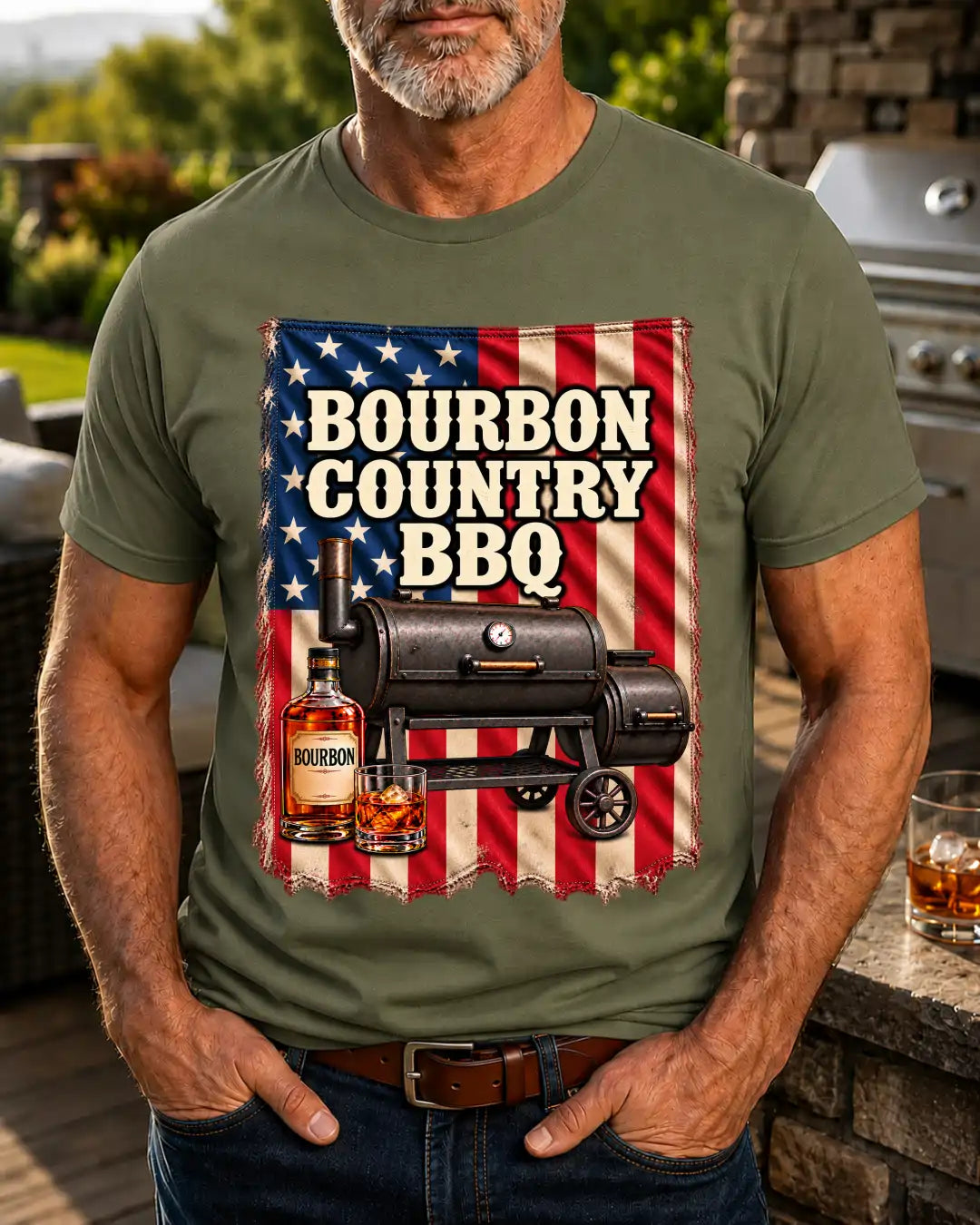 A man wearing an olive green t-shirt with a large graphic print that reads 'Bourbon Country BBQ' over an American flag background, featuring a black smoker grill and a bourbon bottle.