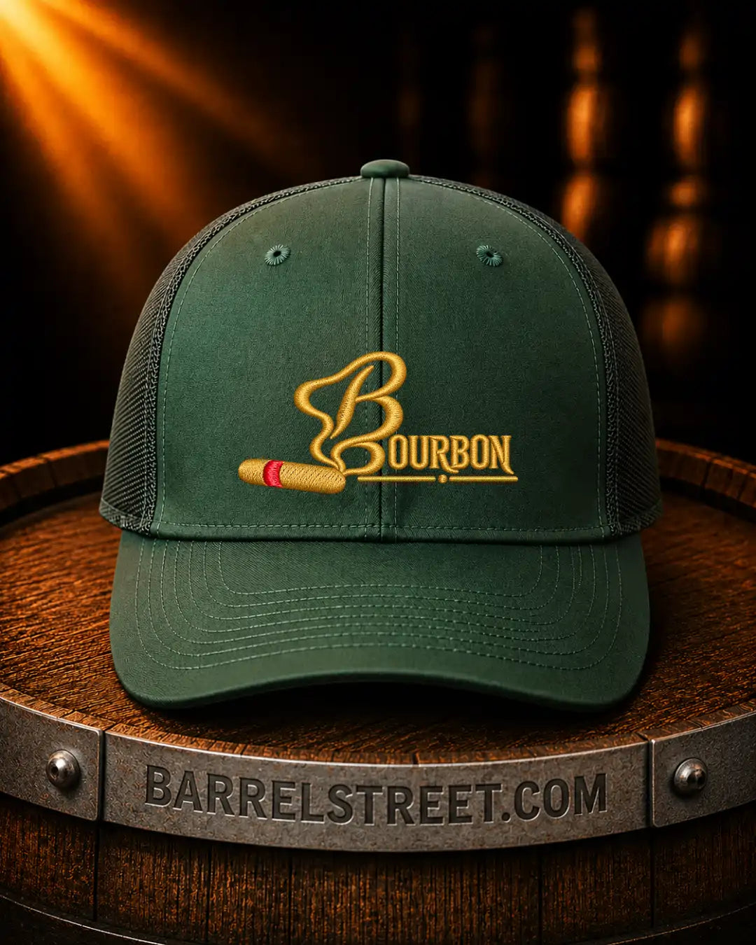 A dark green trucker-style cap with a gold embroidered Bourbon logo and a small red accent, displayed on a wooden barrel with a Barrelstreet.com band around it.