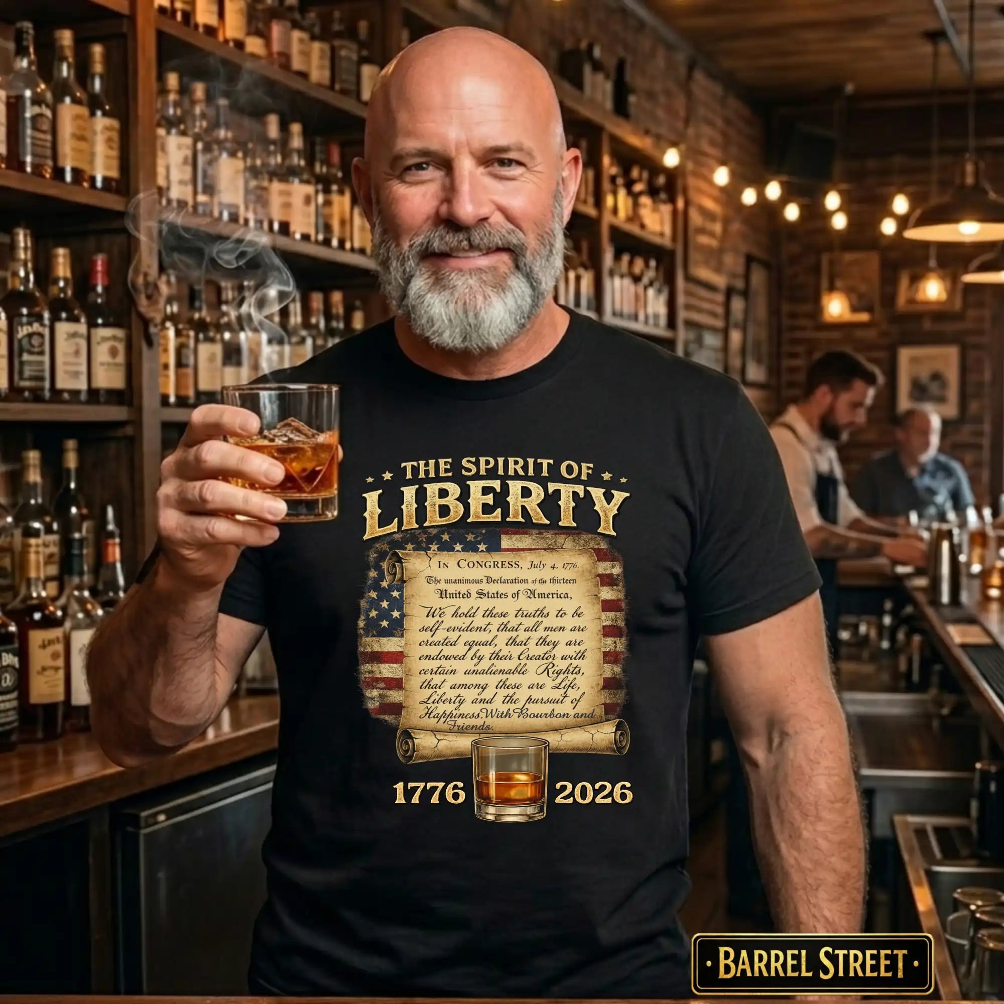 Man holding a glass of whiskey in a bar wearing a 'The Spirit of Liberty' t-shirt.