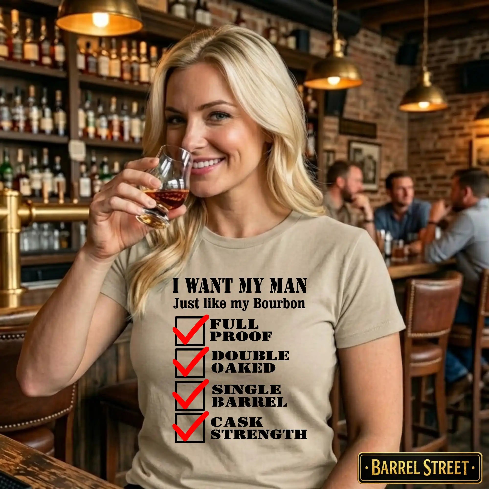 Woman in a bar wearing a t-shirt with a bourbon-themed message, holding a glass of bourbon.