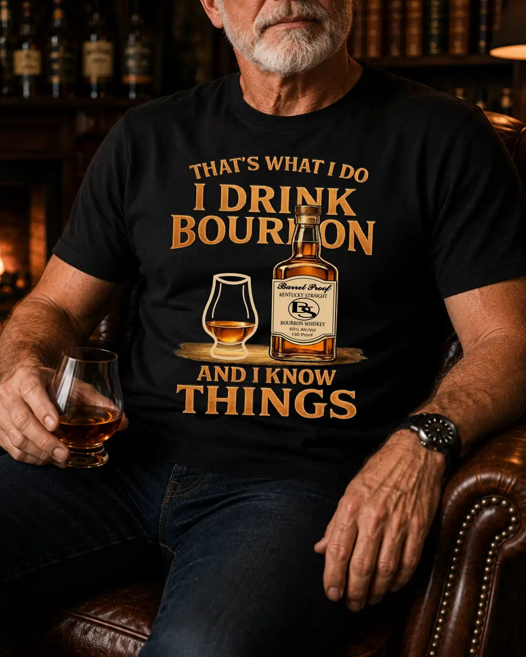 A man wearing a black graphic t-shirt with a humorous bourbon quote and a bottle illustration, sitting in a leather armchair in a dimly lit bar setting.